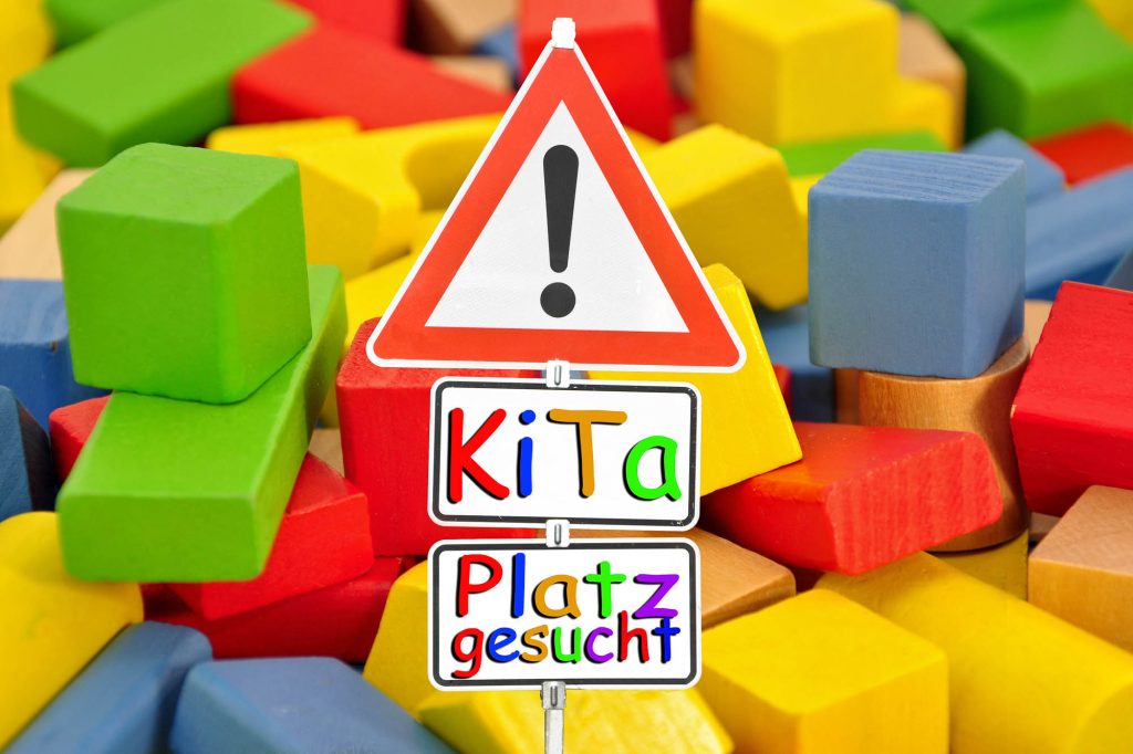 Verschiedene Bunte Holzwürfel, dazu die Grafik eines Verkehrsschildes (Achtung) und die Worte Kitaplatz gesucht